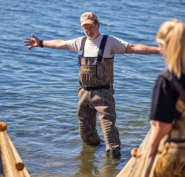 Great Lakes faculty member in the water with arms spread